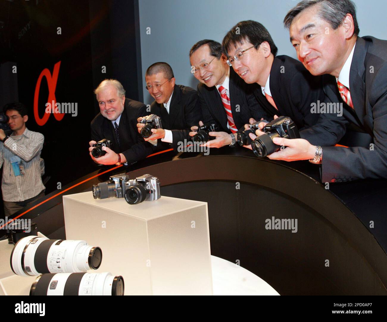 Sony Corp.'s executives and guests pose with the electronics company's new Alpha DSLR-A100 digital cameras in Tokyo Tuesday, June 6, 2006. Sony, the first to market a digital camera in 1981, is making a late entry into the higher end segment of digital single-lens reflex cameras, targeting 10 percent of the global market. From left: Larry Kiansen, Carl Zeiss Asia Pacific President and CEO, photographer Kazuyoshi Miyoshi, and Sony executives Yutaka Nakagawa, Toru Katsumoto and Kiyoshi Shikano. (AP Photo/Shizuo Kambayashi) Stockfoto