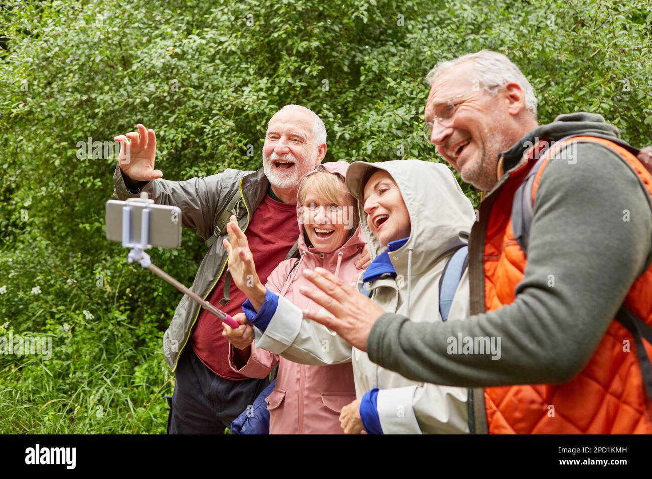 Glückliche ältere Paare winkten während der Reise über ein Smartphone im Wald auf einem Videoanruf zu Stockfoto