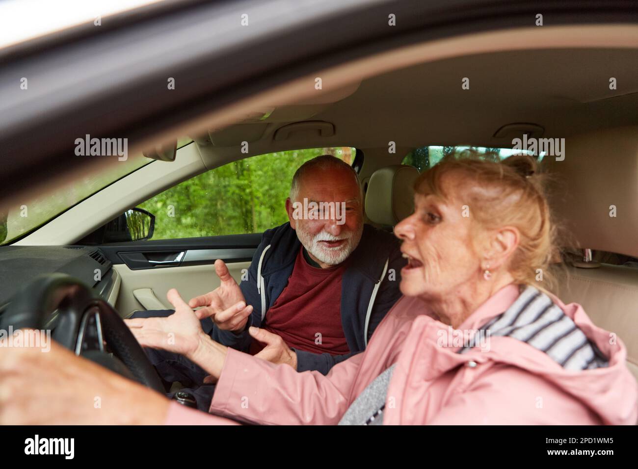 Senioren-Gesten beim Gespräch mit Autofahrerin während einer Autofahrt Stockfoto