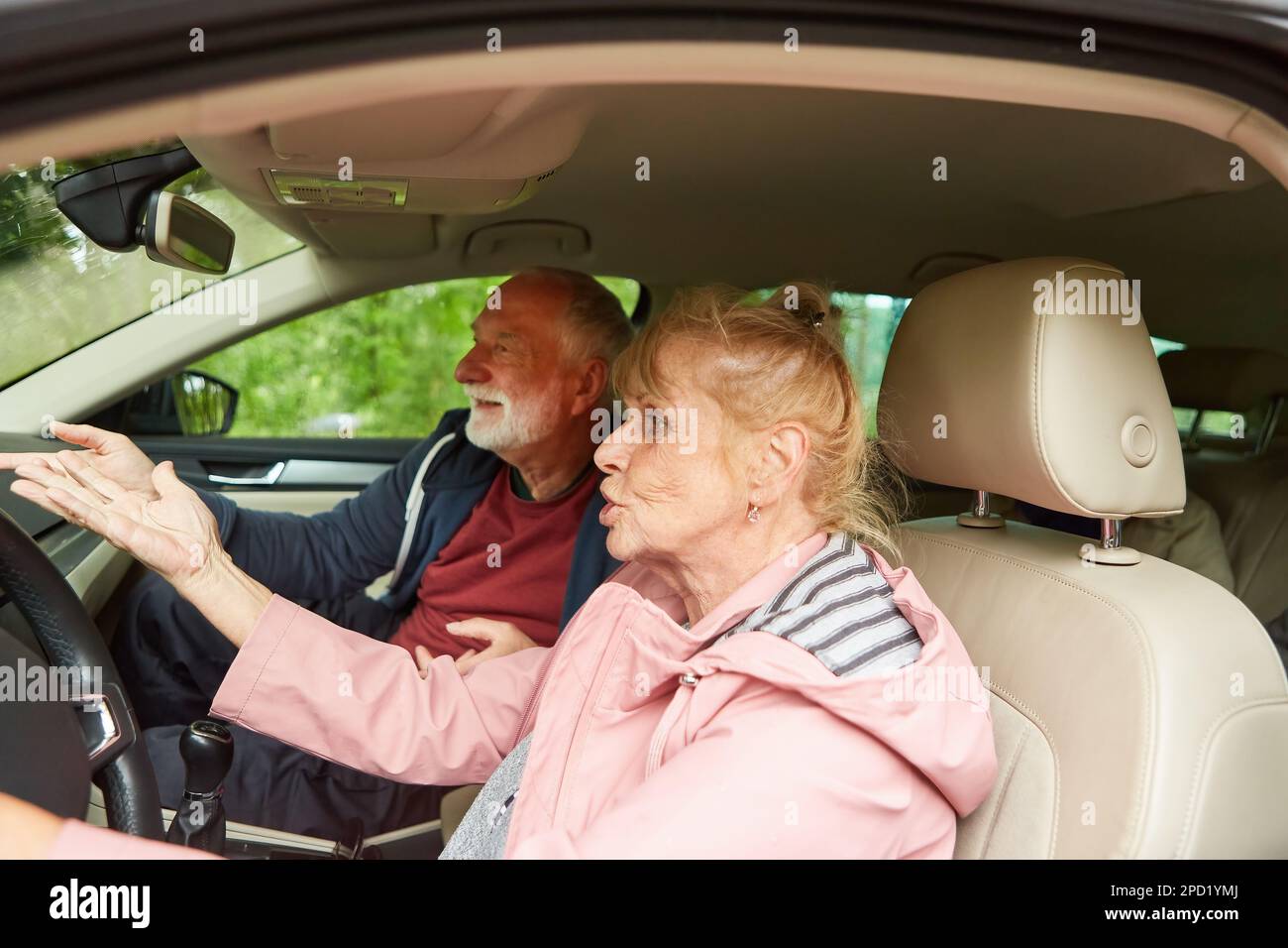 Wütende Gesten älterer Männer und Frauen während des Autogesprächs während einer Autofahrt Stockfoto