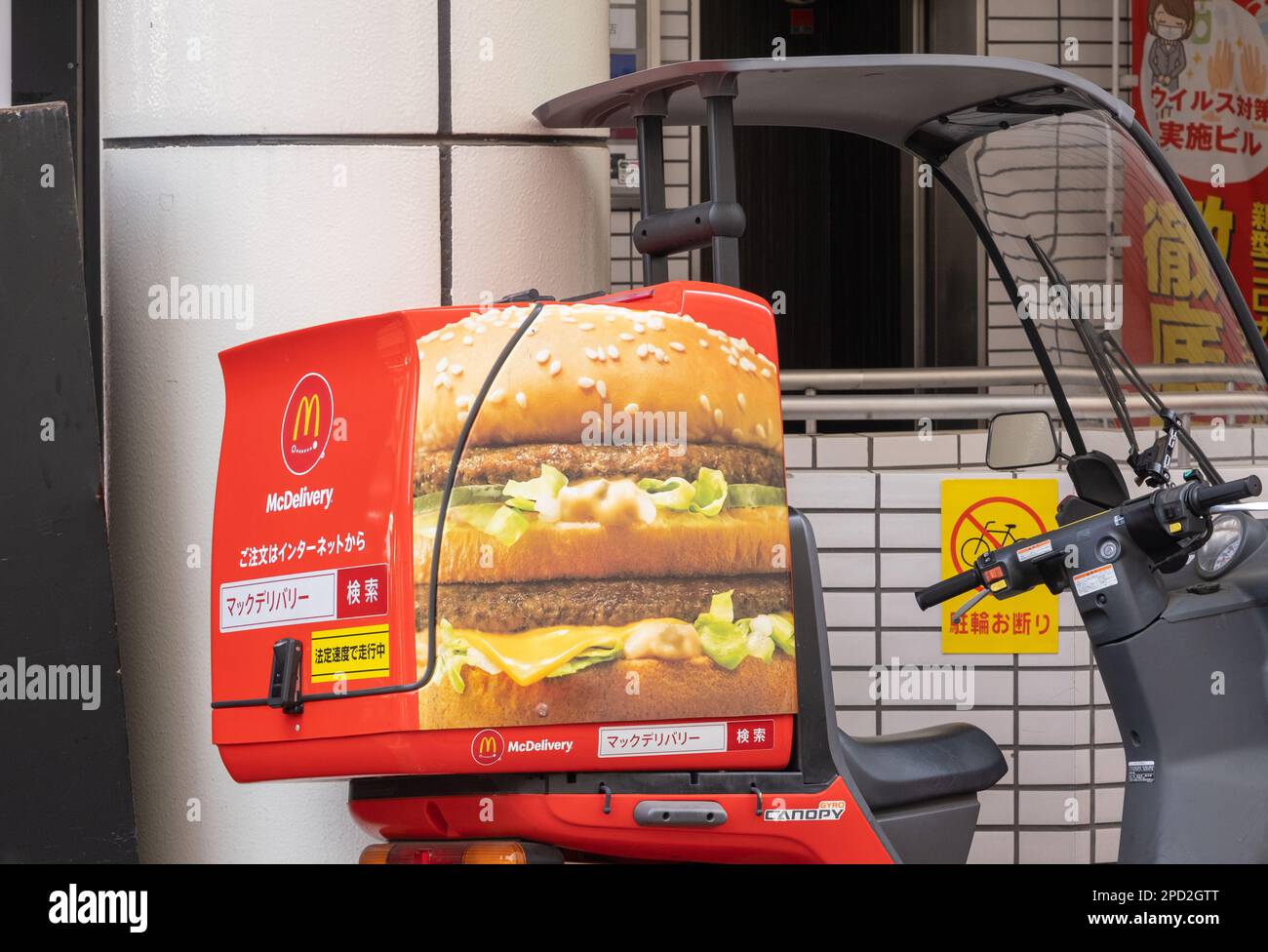 Ein Seitenbild des hinteren Kofferraums und ein Big Mac-Bild eines 3-rädrigen McDonald's Liefermotorrads mit Dach. Stockfoto