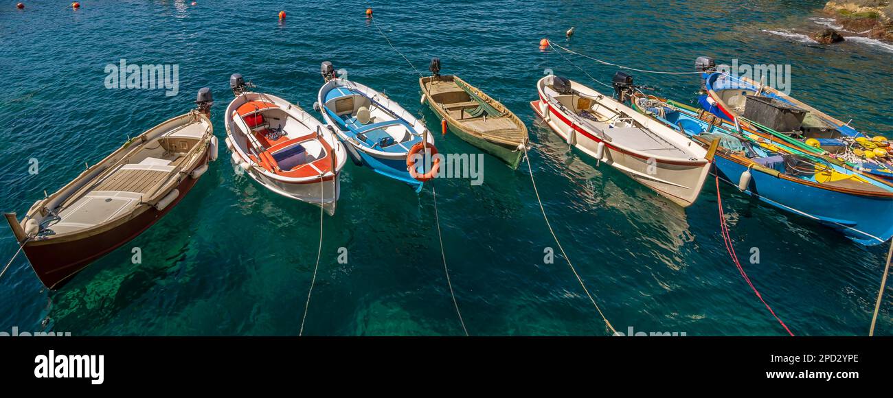 Sieben hölzerne Boote stehen im Meer in Manarola, Cinque Terre, Italien Stockfoto