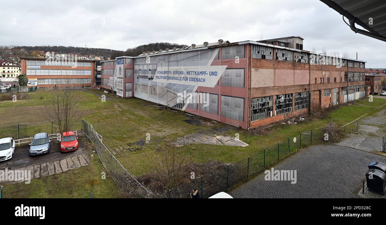 Eisenach, Deutschland. 14. März 2023. Das Industriedenkmal „O1“, ehemals das Hauptwerk der BMW-Automobilproduktion, auf dem Gelände des ehemaligen Eisenach-Automobilwerks, ist teilweise in eine Plane gewickelt. Die Stadt plant den Bau einer multifunktionalen Halle in dem Gebäude, das seit mehr als 20 Jahren leer steht und hauptsächlich als Sportanlage für Schule, Wettkampf und Clubsport genutzt wird. Kredit: Martin Schutt/dpa/Alamy Live News Stockfoto