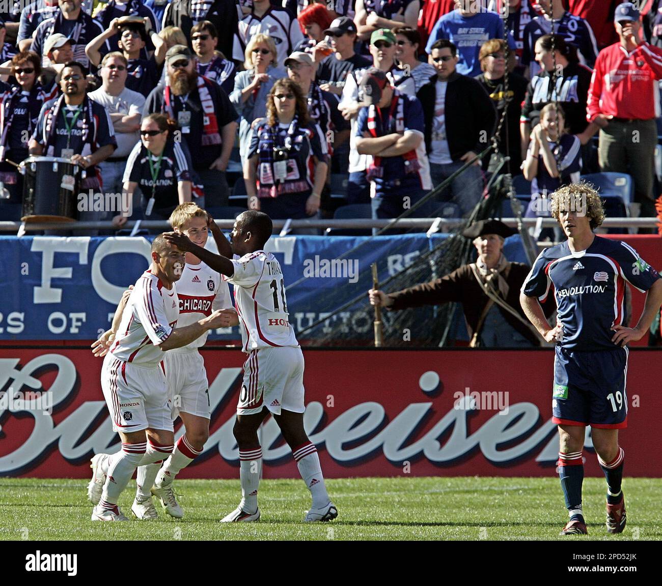 New England Revolution's Tony Lochhead (19) looks away as Chicago Fire's Chris Rolfe, second from left, celebrates his goal with teammates Chris Armas, left, and Thiago (10) during second half of MLS soccer game in Foxborough, Mass., Sunday, April 30, 2006. Chicago won 2-1. (AP Photo/Chitose Suzuki) Stockfoto