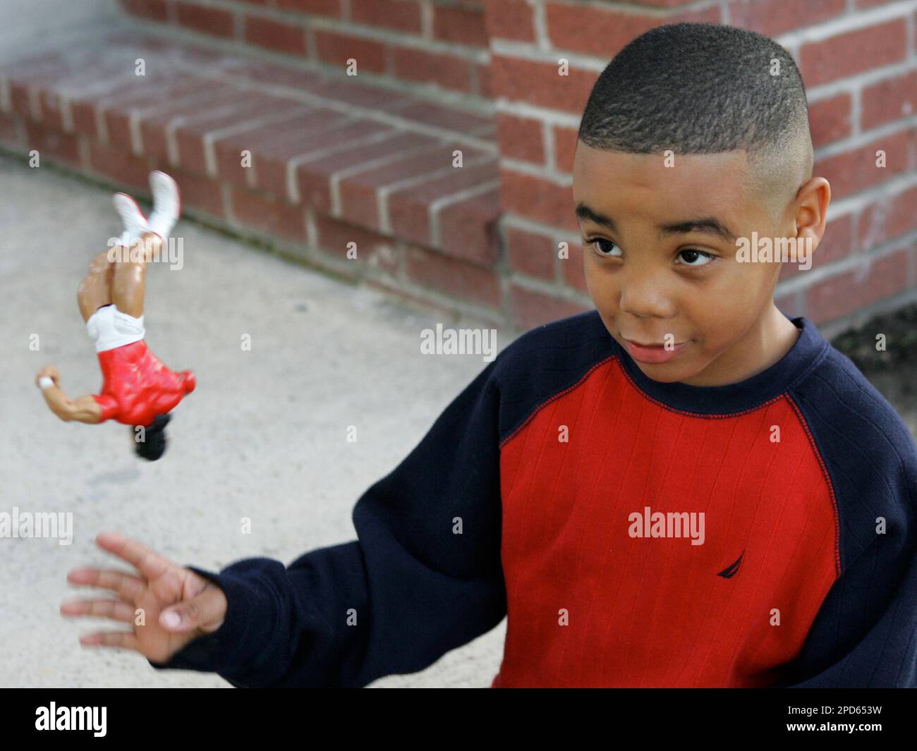 ** ADVANCE FOR MONDAY, APRIL 24 **Michael Watts plays with one of his new toys at his family home in New Orleans March 15, 2006. Watts, now living in Memphis, Tenn., came back to New Orleans to visit family and returned to his home that was flooded by Hurricane Katrina. Watts lost all of his toys during the hurricane and now keeps the new ones with him in a small suitcase. (AP Photo/Judi Bottoni) Stockfoto