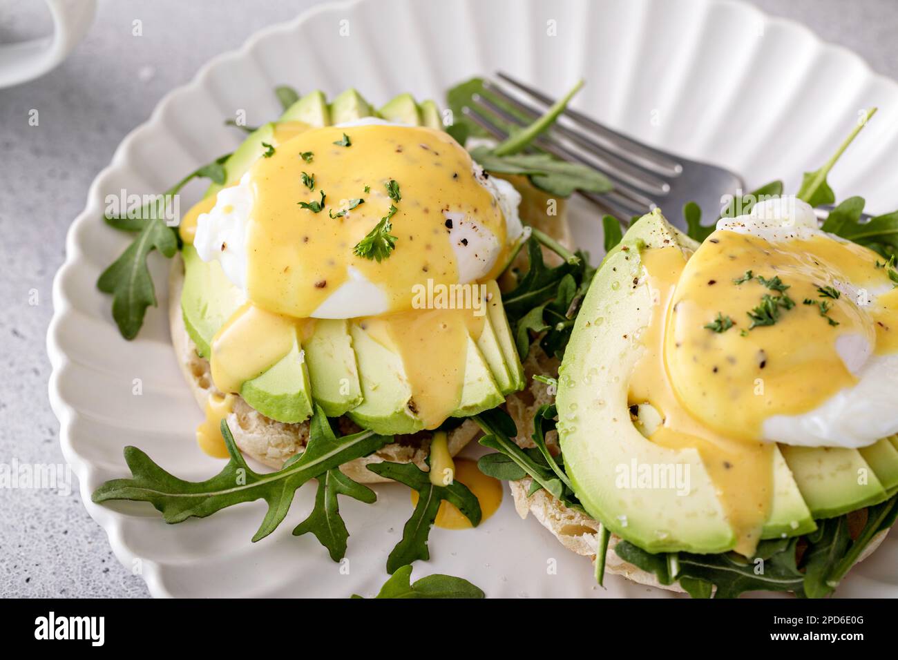 Gesundes Ei benedict Sandwich mit Avocado und Rucola, Frühstücksidee Stockfoto