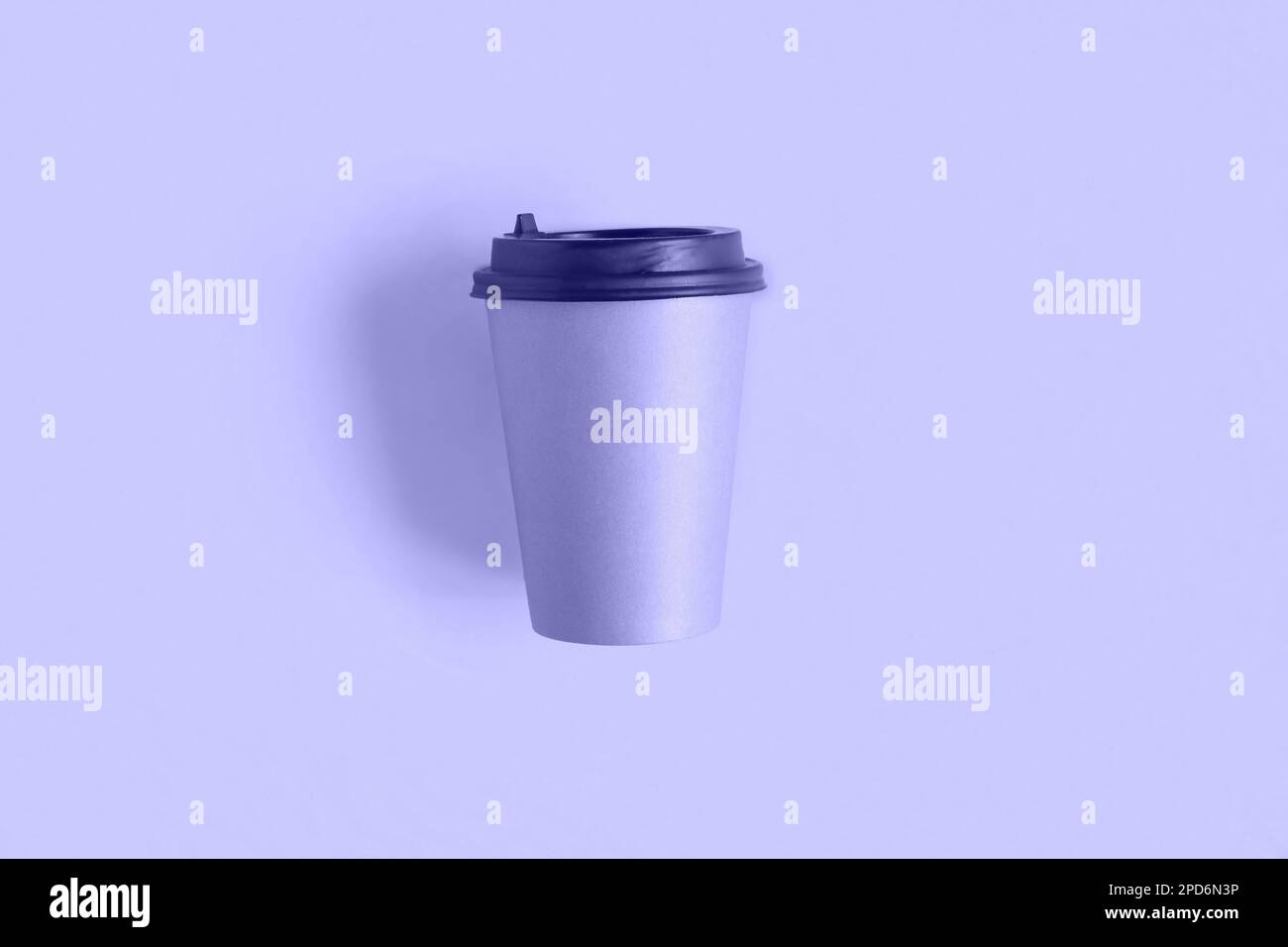 Sehr Riskant. Farbe des Jahres 2022. Draufsicht einer Kaffeepapierbecher. Modell mit Deckel. Ein handgefertigter Pappbecher für Kaffee oder Tee auf violettem Hintergrund. Fla Stockfoto