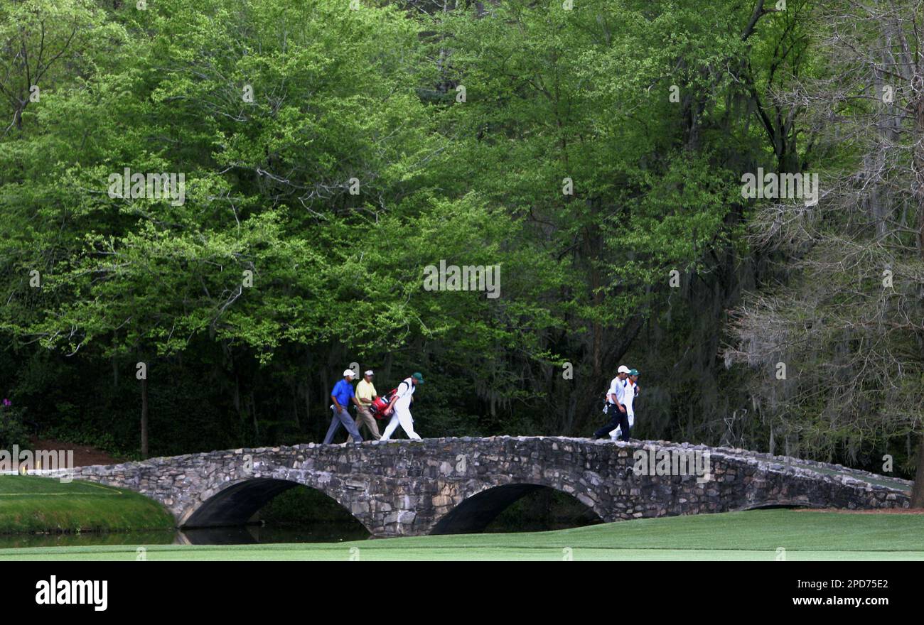 Tiger Woods, left, Edoardo Molinari from Italy and Robert Allenby, right, from Australia cross the Byron Nelson bridge on the 13th hole during second round play of the Masters golf tournament at the Augusta National Golf Club in Augusta, Ga., Friday, April 7, 2006. (AP Photo/Rob Carr) Stockfoto