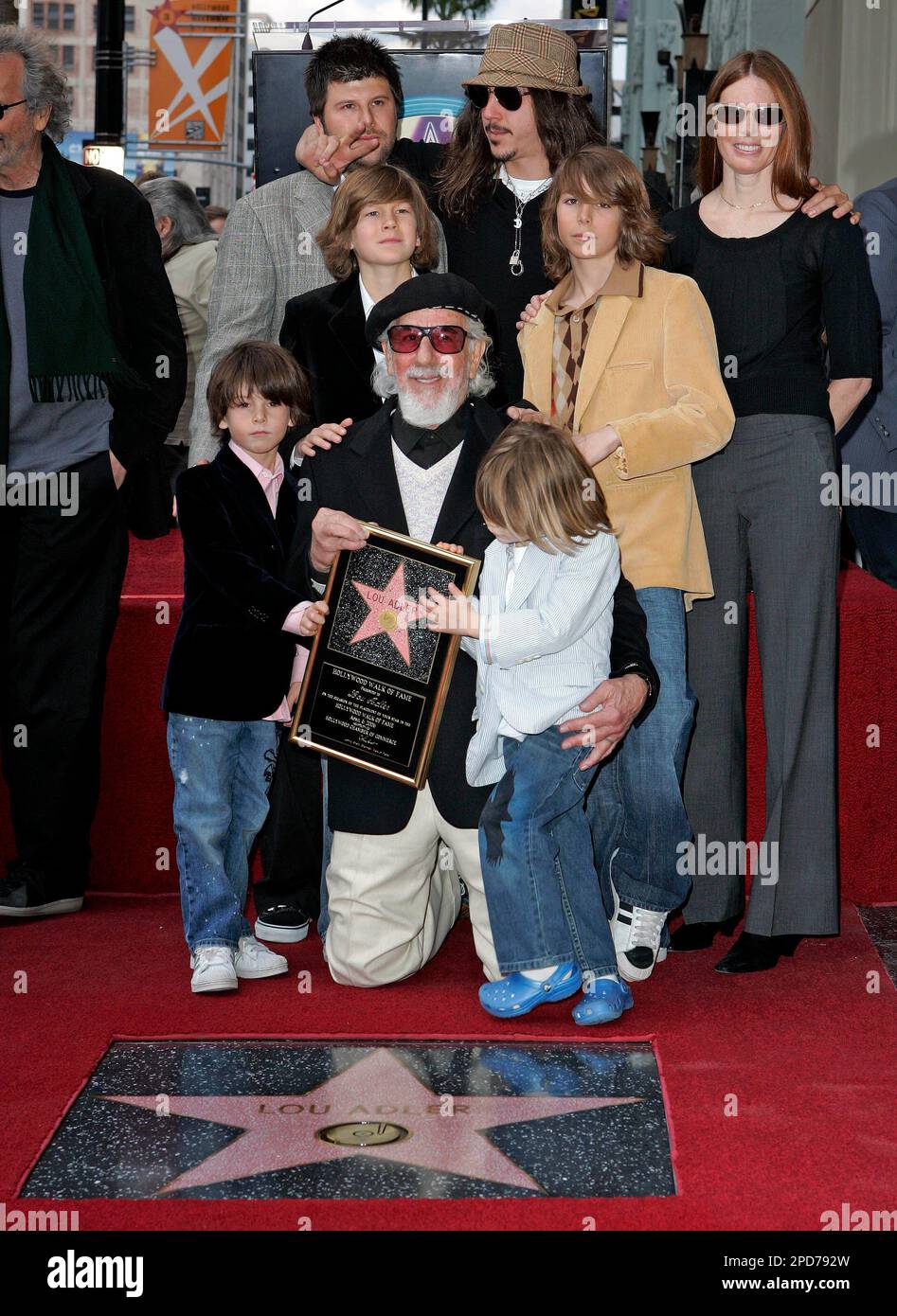 Grammy-winning music producer Lou Adler, who launched "The Rocky Horror Picture Show" into cult status, is honored Thursday, April 6, 2006, with a star on the Hollywood Walk of Fame in the Hollywood section of Los Angeles. Surrounding Adler are family members, back row from left, Nic, Cisco, wife Page Hannah, second row from left, Ike, Manny, and bottom row, Oscar, and Pablo. (AP Photo/Kevork Djansezian) Stockfoto
