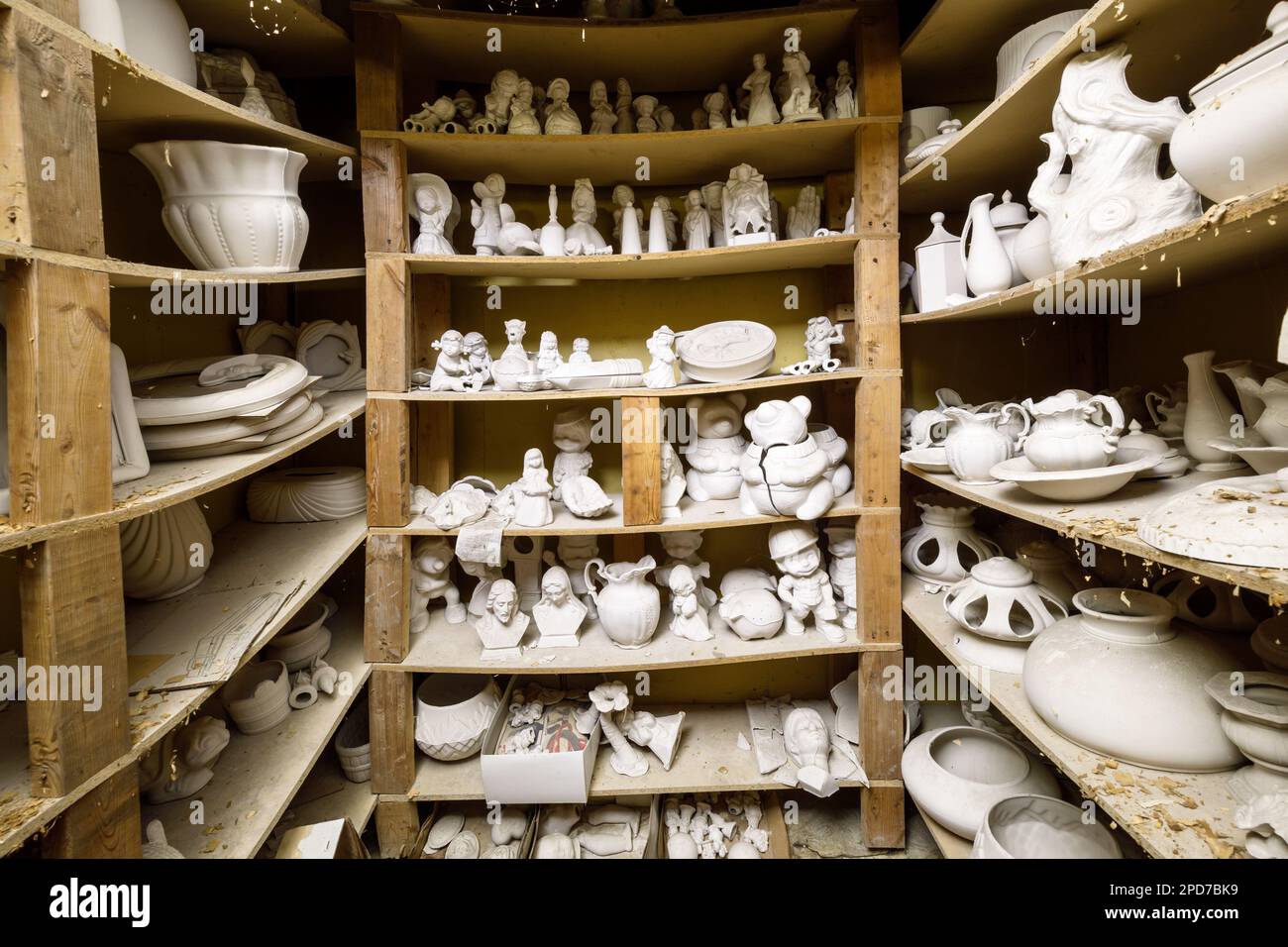Dutzende unlackierter Keramikfiguren auf Regalen. Stockfoto