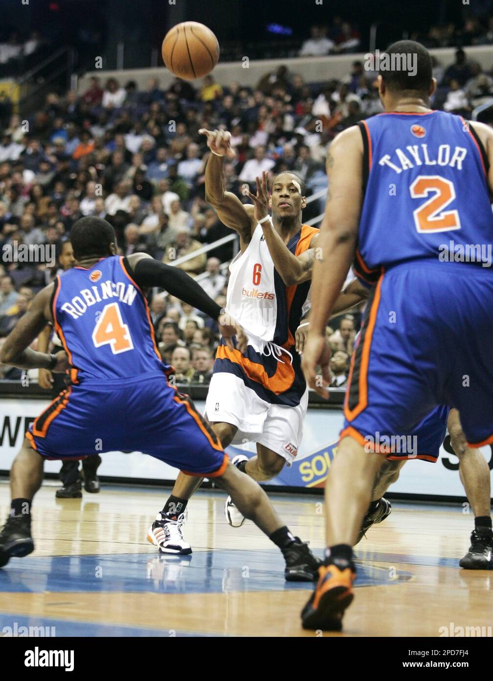 Washington Wizards' Antonio Daniels (6) passes the ball between New York Knicks' Nate Robinson (4) and Maurice Taylor (3) during the third quarter of their NBA basketball game, Tuesday, April 4, 2006, in Washington. (AP Photo/Haraz N. Ghanbari) Stockfoto