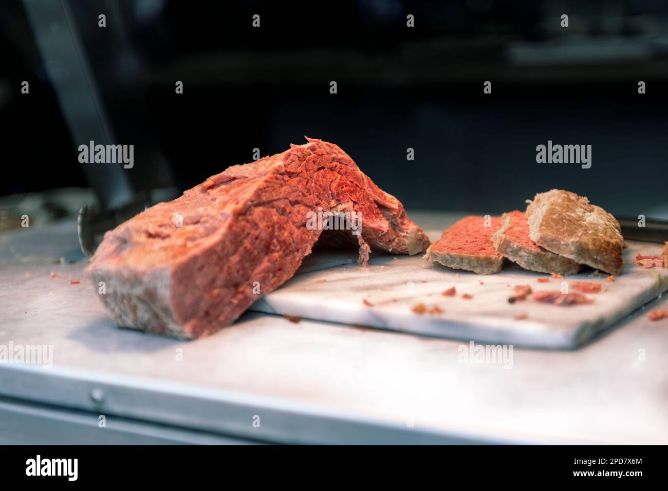 Ein Haufen Fleisch auf einer Marmorplatte in einem Feinkostladen. Stockfoto