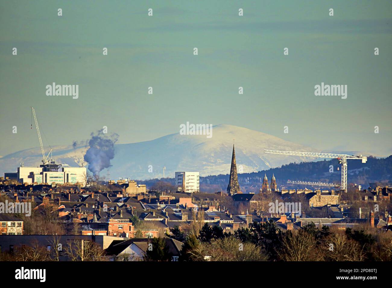 Glasgow, Schottland, Vereinigtes Königreich, 14. März 2023. Wetter in Großbritannien: Schnee über Nacht und Graupelschauer hörten auf und ein sonniger später Nachmittag sah die Stadt in Licht gebadet. Schneebedeckter tinto-Hügel, der höchste im Zentrum von schottland, auf den der Turm des Cottiers-Theaters in der Stadt zeigte. Credit Gerard Ferry/Alamy Live News Stockfoto