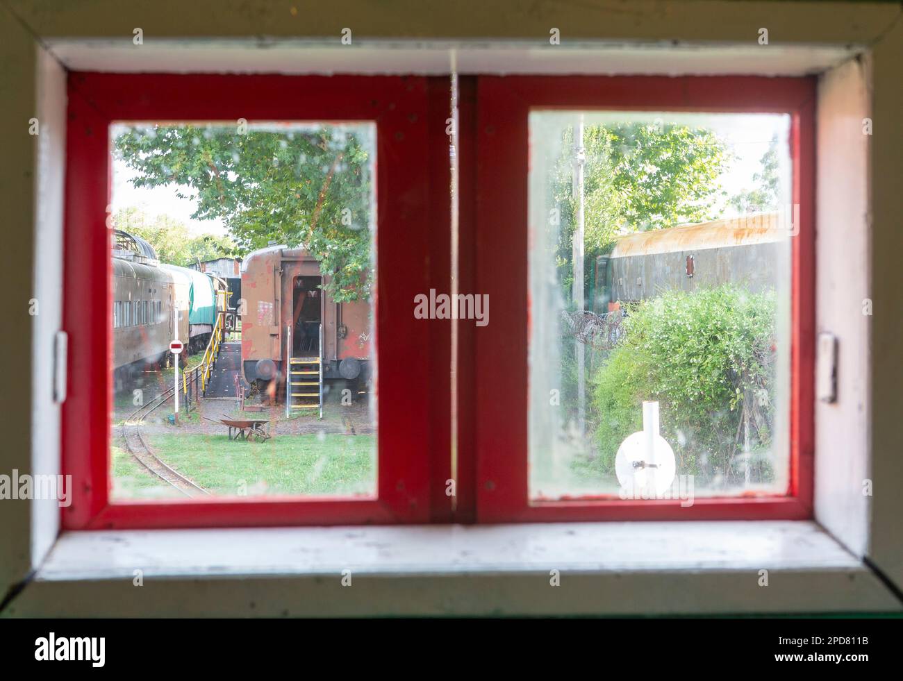 Altes Holzfenster mit Blick auf verlassene Züge Stockfoto