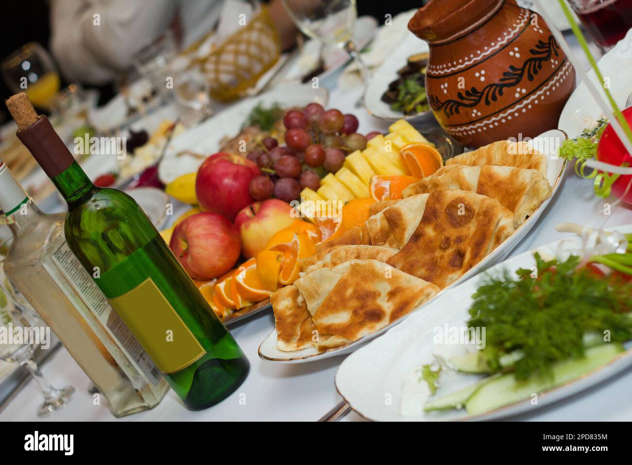 Wunderschöner Banketttisch mit Speisen und Getränken. Wein, Snacks, Obst und andere Speisen stehen auf dem Tisch Stockfoto