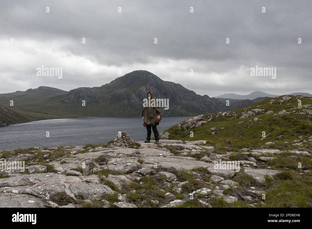 Männlicher Walker in Rain Poncho Outdoor, Loch Suainaval, Lewis, Isle of Lewis, Hebriden, Outer Hebrides, Western Isles, Schottland, Großbritannien Stockfoto