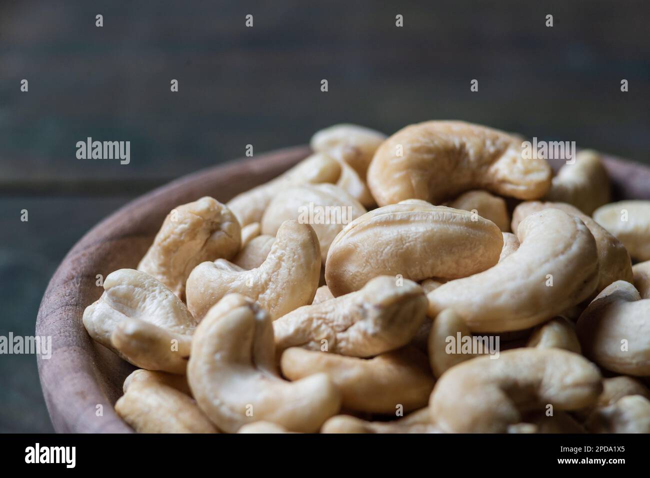 Schüssel mit rohen Cashew Bio-Nüssen, geschält auf Holztisch rustikaler Tisch, gesunder vegetarischer veganer Snack indische Walnuss Anacardium occidentale Sacktuch c Stockfoto