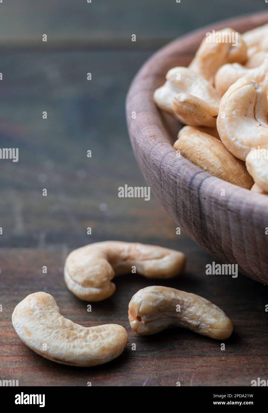 Schüssel mit rohen Cashew Bio-Nüssen, geschält auf Holztisch rustikaler Tisch, gesunder vegetarischer veganer Snack indische Walnuss Anacardium occidentale Sacktuch c Stockfoto