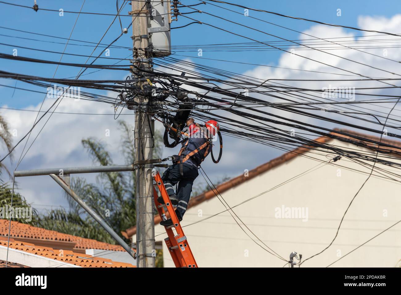 Telekommunikations- und Stromkabel, Techniker, die am Telegrafenmast arbeiten, Gerätewartung, Telegrafenkabel Stockfoto