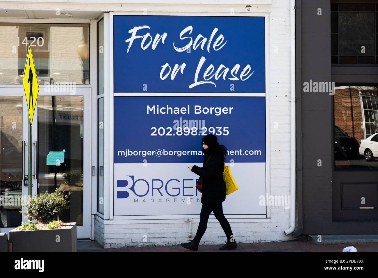 Washington, USA. 14. März 2023. Eine Frau geht am 14. März 2023 an Wohnungen vorbei, die verkauft oder geleast werden. Die USA Der Verbraucherpreisindex (CPI) für alle Verbraucher in Städten stieg im Februar um 0,4 Prozent, laut Regierungsdaten, die am Dienstag veröffentlicht wurden. Kredit: Aaron Schwartz/Xinhua/Alamy Live News Stockfoto