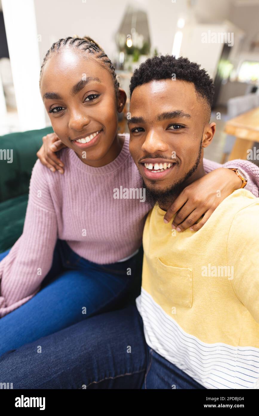 Glückliches afroamerikanisches Paar, das auf dem Sofa sitzt und Videogespräche im Wohnzimmer führt. Verbringen Sie Zeit, Lebensstil und häusliches Leben. Stockfoto