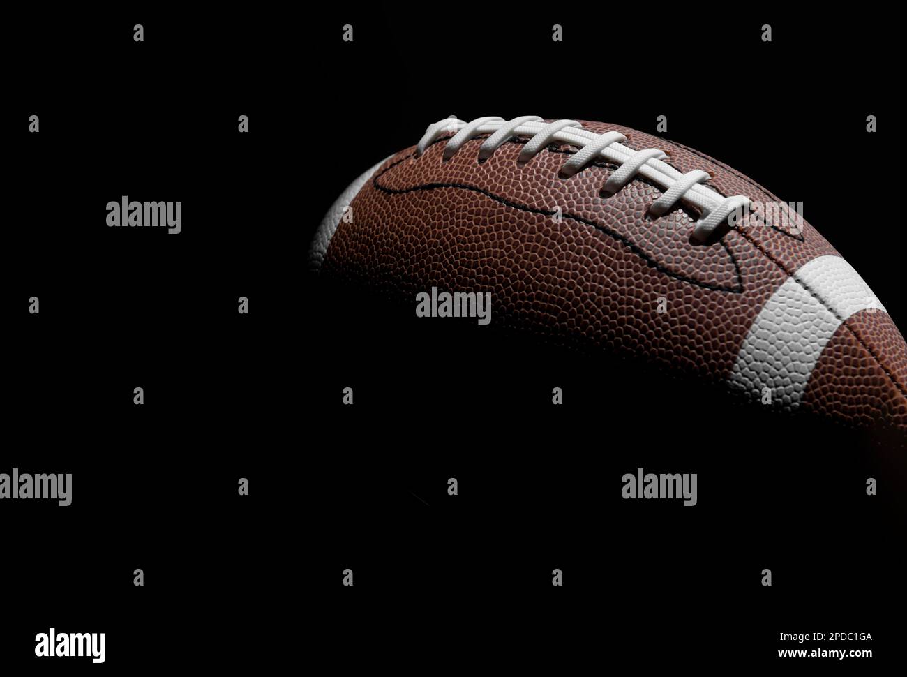 Nahaufnahme des American Football Balls auf schwarzem Hintergrund. Horizontales Sportposter, Grußkarten, Kopfzeilen, Website und App Stockfoto
