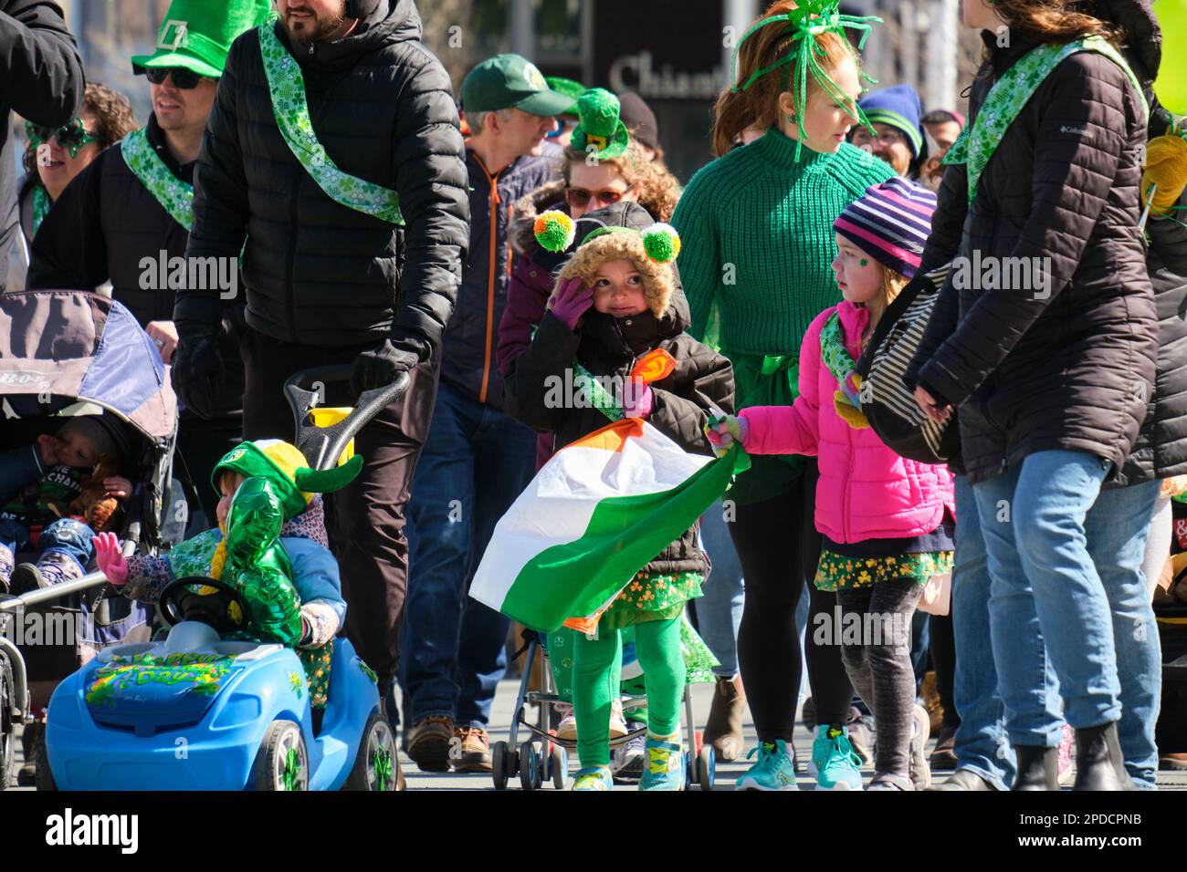 St. Patrick's Day Parade: Grün gekleidete Kinder marschieren entlang der Parade und winken. Halifax, Kanada, März 2023 Stockfoto