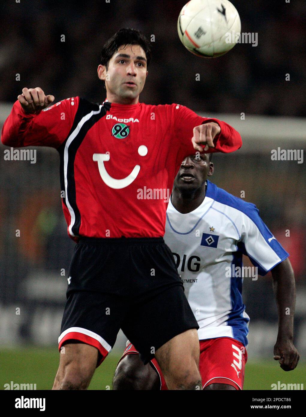 Hanover's Vahid Hashemian of Iran, left, and Hamburg's Thimothee Atouba, right, challenge for the ball during the German first soccer division match between Hanover 96 and Hamburger SV in the AWD Arena, Hanover, northern Germany on Wednesday, Jan. 8, 2006. (AP Photo/Kai-Uwe Knoth) ** EMBARGOED AGAINST ANY MOBILE USE (NO MMS) UNTIL 23.00 GMT ** Stockfoto