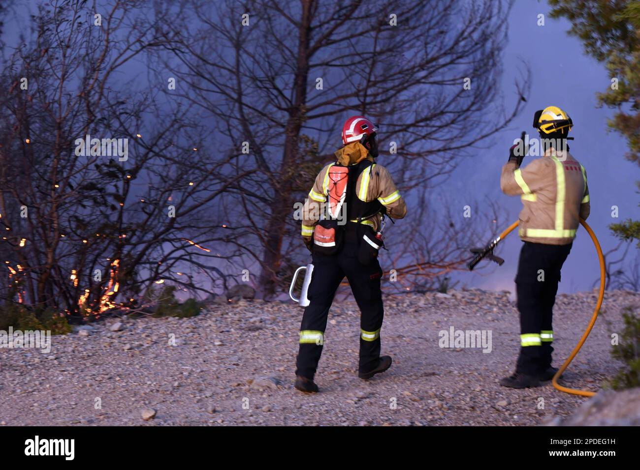 Calafell, Spanien. 14. März 2023. Zwei Feuerwehrleute überwachen den Brandbereich während des Waldbrandes in Calafell Ein Brand in Calafell brennt 13 Hektar und zwingt Hunderte von Menschen, in ihren Häusern in zwei Vierteln des betroffenen Gebiets eingeschlossen zu werden. (Foto: Ramon Costa/SOPA Images/Sipa USA) Guthaben: SIPA USA/Alamy Live News Stockfoto