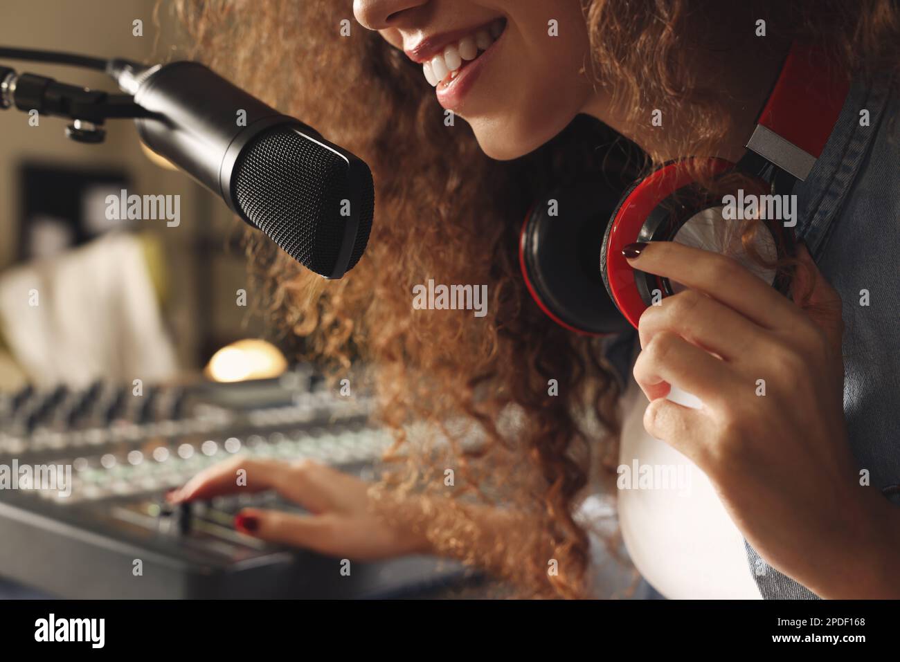 Eine afroamerikanische Frau, die als Radio-Moderatorin in einem modernen Studio arbeitet, Nahaufnahme Stockfoto