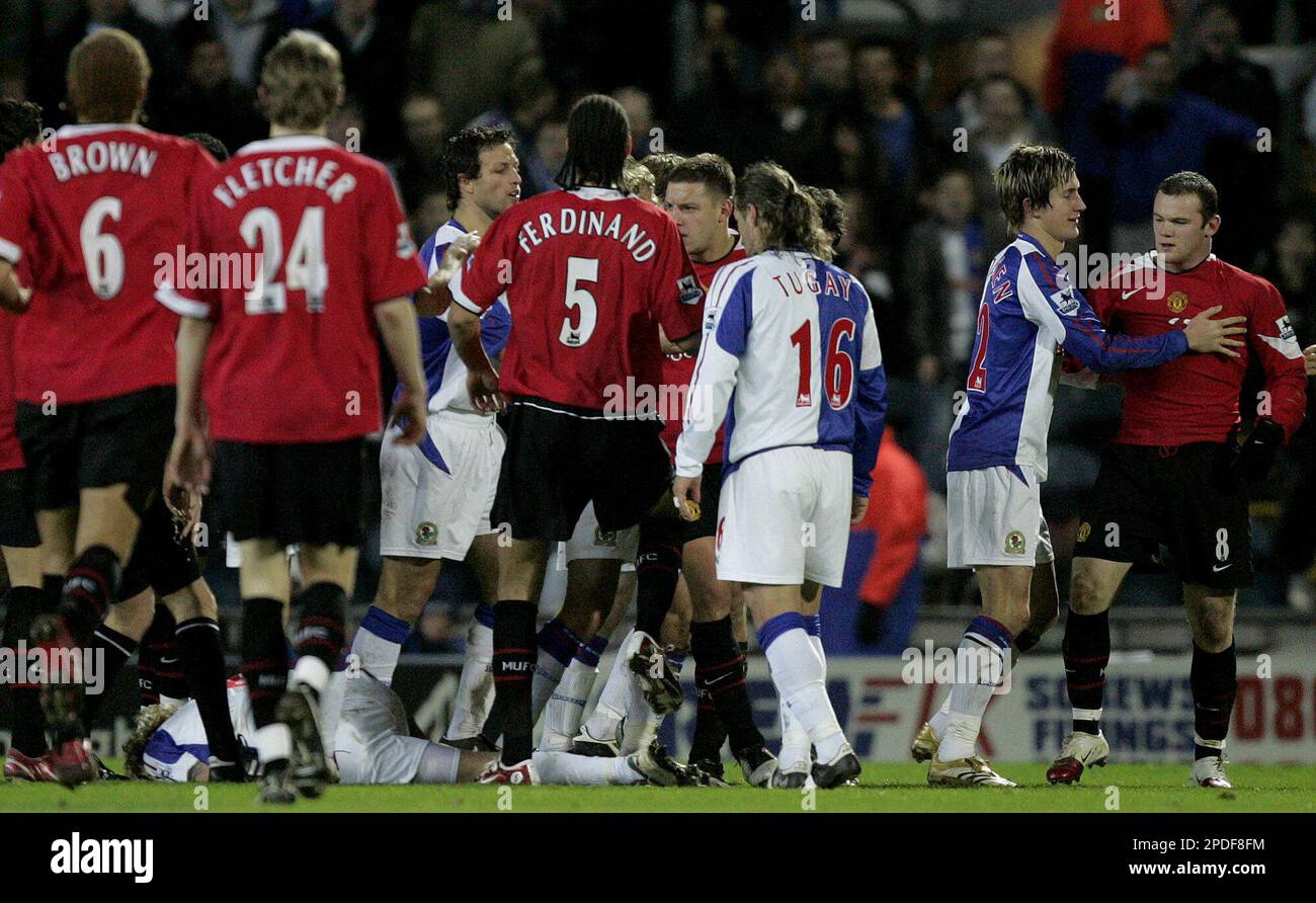 Blackburn Rovers' Morten Gamst Pedersen, second right, restrains Manchester United's Wayne Rooney, far right, after an Alan Smith challenge left Blackburn's Robbie Savage lying on the ground during the English League Cup semi-final 1st leg soccer match at Ewood Park, Blackburn, England, Wednesday Jan. 11, 2006. (AP Photo/Dave Thompson) Stockfoto