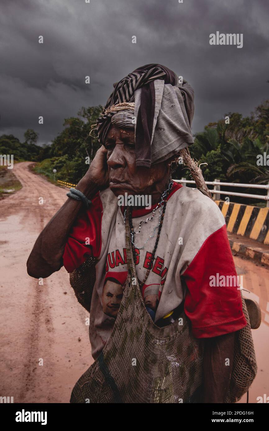 Eine ältere Frau mit einer Tasche spaziert am 2017. September im Inneren von Papua bei bewölktem Himmel in Indonesien Stockfoto