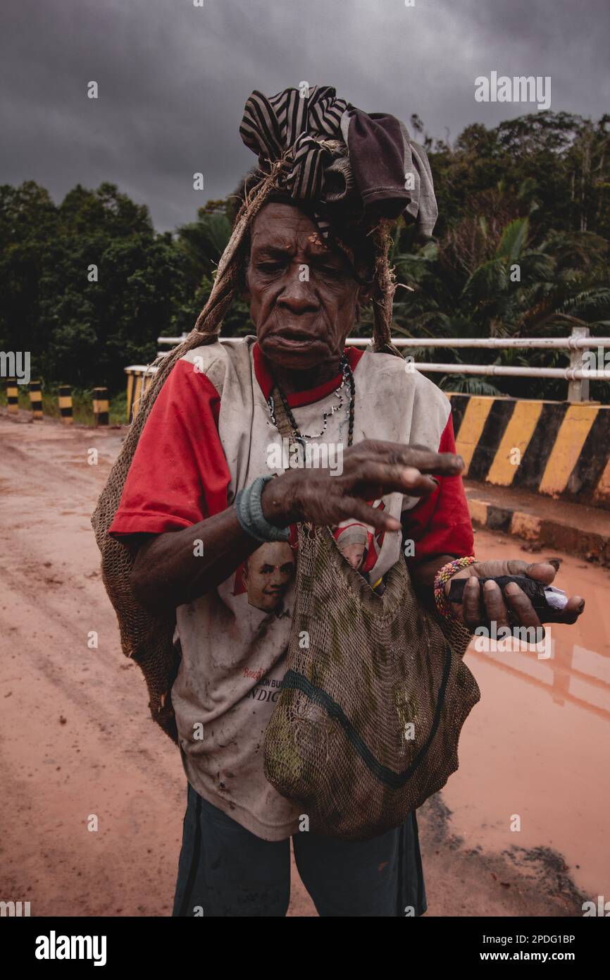 Eine ältere Frau mit einer Tasche spaziert am 2017. September im Inneren von Papua bei bewölktem Himmel in Indonesien Stockfoto