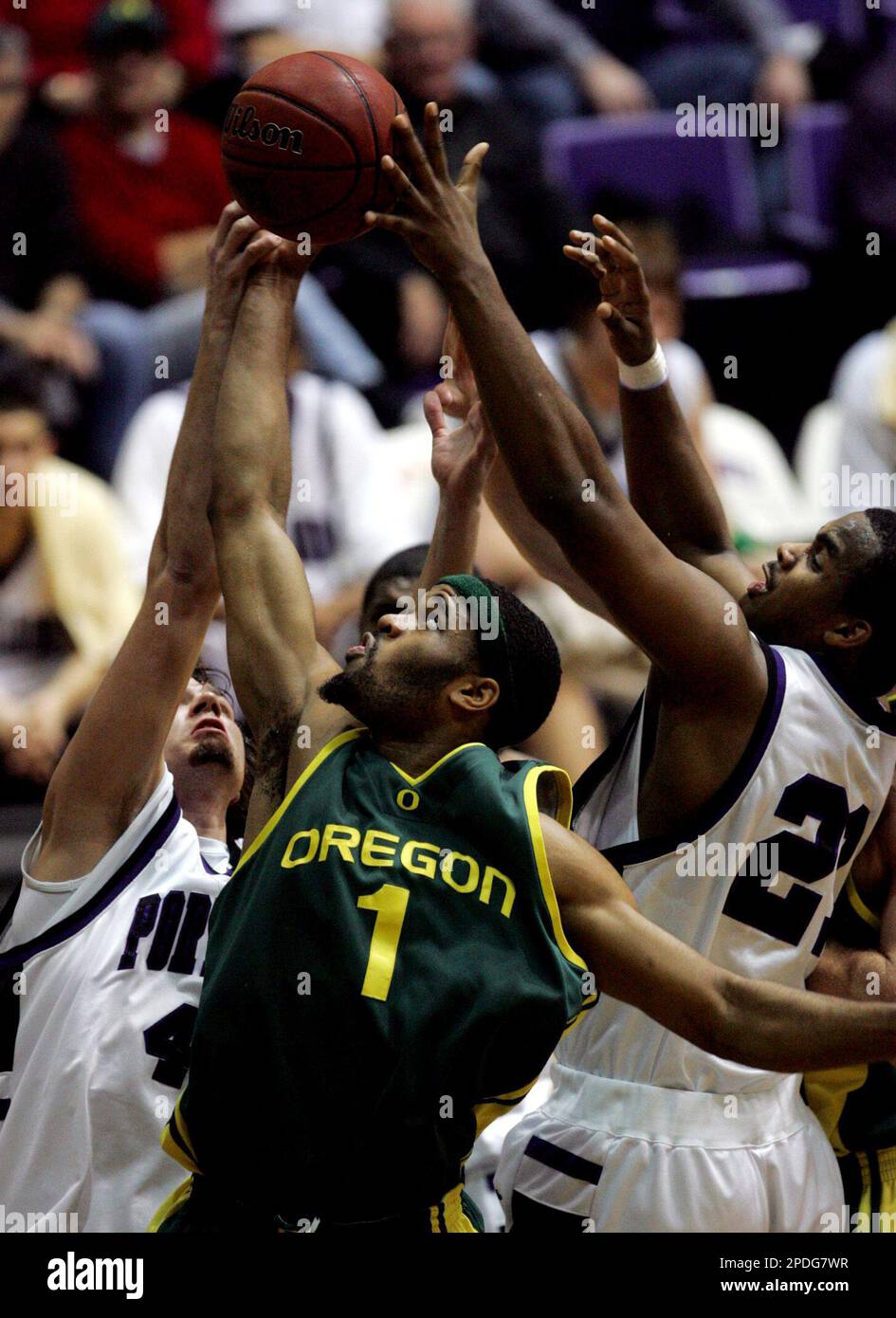 Oregon's Malik Hairston (1) goes up for a rebound with Portland's Ben Sullivan, left, and Marcus Lewis, right, during the first half of a college basketball game Thursday, Dec. 22, 2005, in Portland, Ore. (AP Photo/Rick Bowmer) Stockfoto
