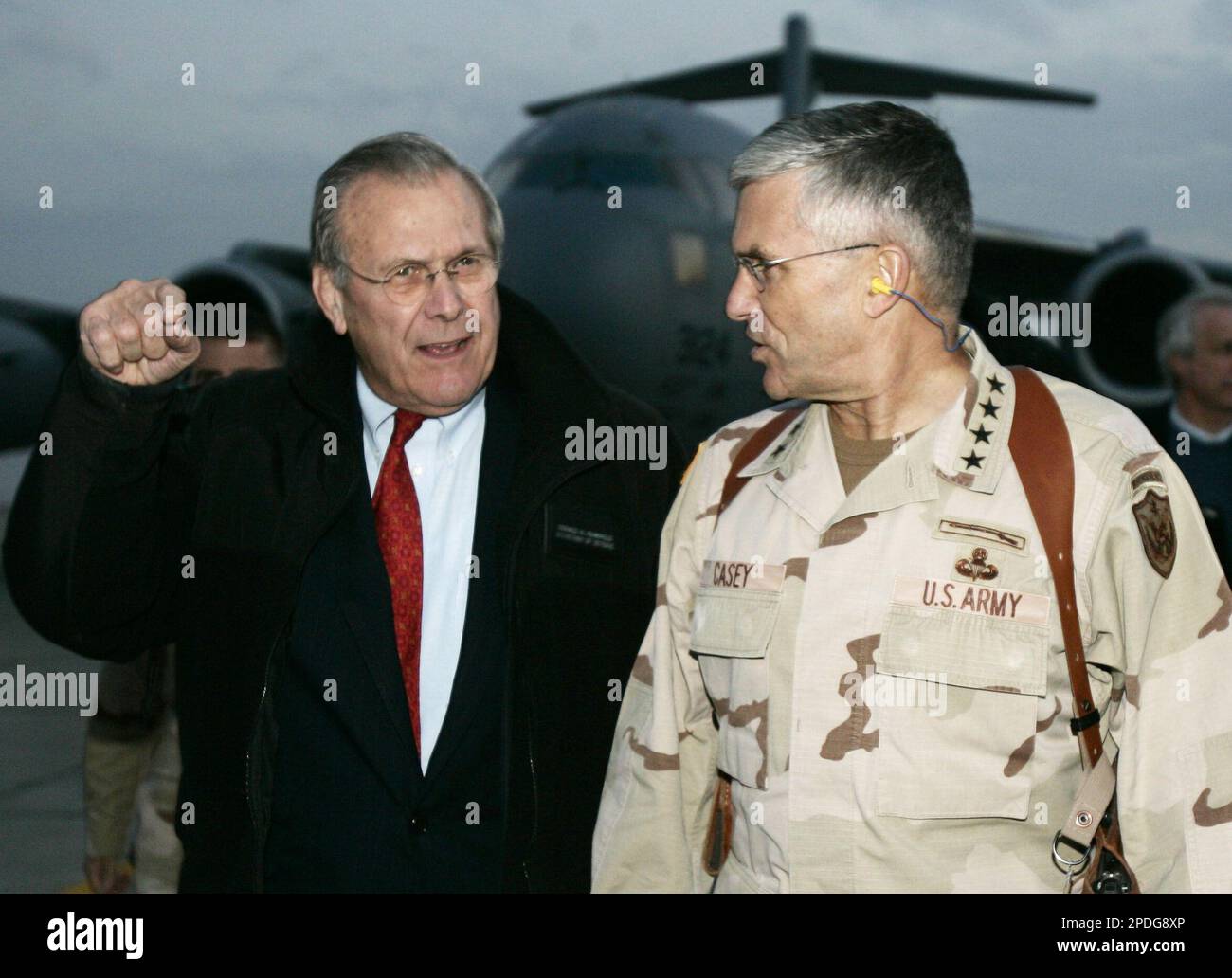 U.S. Secretary of Defense Donald H. Rumsfeld, left, walks with Gen. George Casey, the top U.S. officer in Iraq, after arriving by transport plane in Baghdad, Iraq, Thursday, Dec. 22, 2005. Rumsfeld flew unannounced to Iraq Thursday to meet with American battlefield commanders and soldiers amid increasing signs the Bush administration is planning new troop cuts. (AP Photo/Jim Young, Pool) Stockfoto