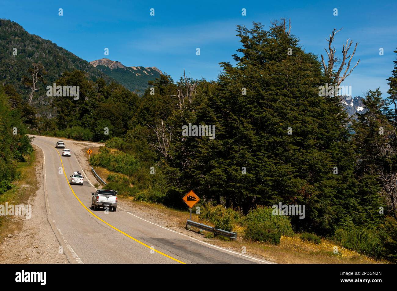 Touristen fahren auf der wunderschönen Landschaft der schneebedeckten Berge auf Ruta 40, Ruta de Los Siete Lagos oder Route of Seven Lakes, Neuquén, Argentinien Stockfoto