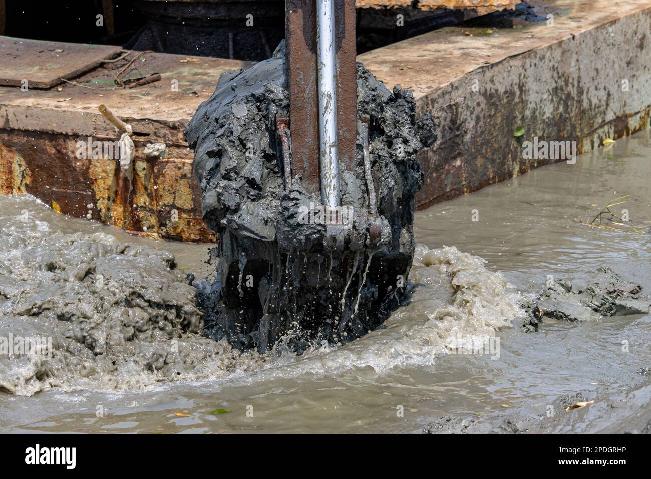 Ausbaggern des Wasserbodens, Ansicht des mit Schlamm gefüllten Löffels des schwimmenden Baggers Stockfoto