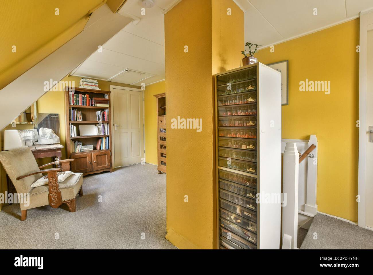 Ein Wohnzimmer mit einem offenen Bücherregal in der Ecke und einem Stuhl auf dem Boden daneben Stockfoto