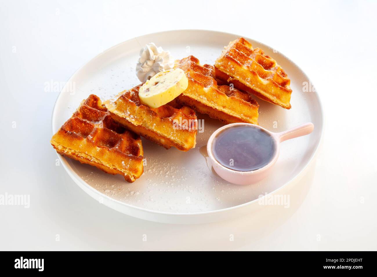 Waffelfrühstück mit Honigbutter Schlagsahne und Ahornsirup. Stockfoto