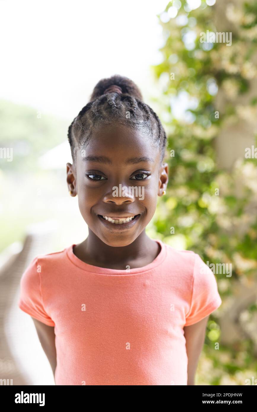 Porträt eines glücklichen afroamerikanischen Mädchens, das in die Kamera schaut und lächelt Stockfoto