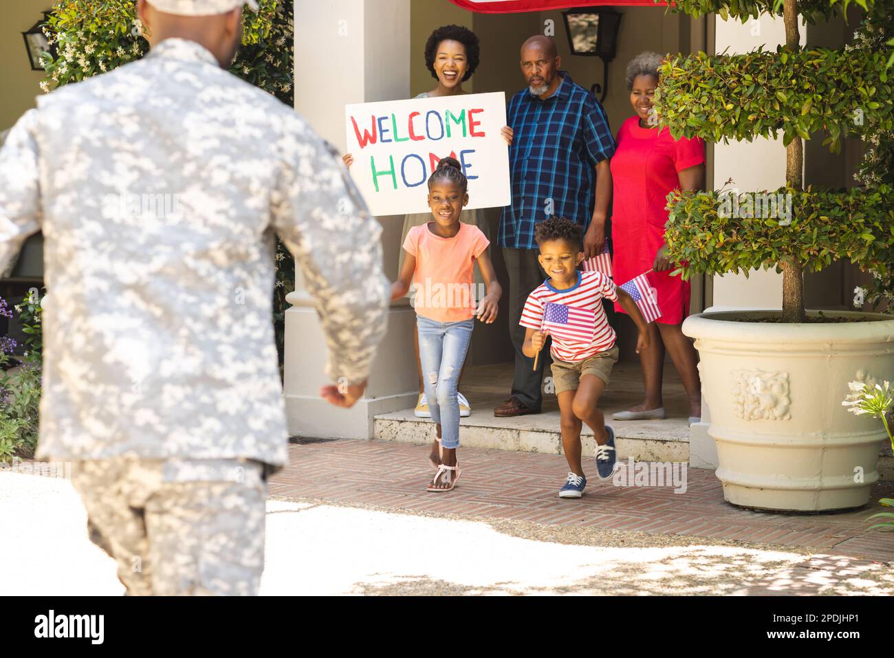 Glücklicher afroamerikanischer Soldat in Militäruniform, der seine Familie begrüßt Stockfoto