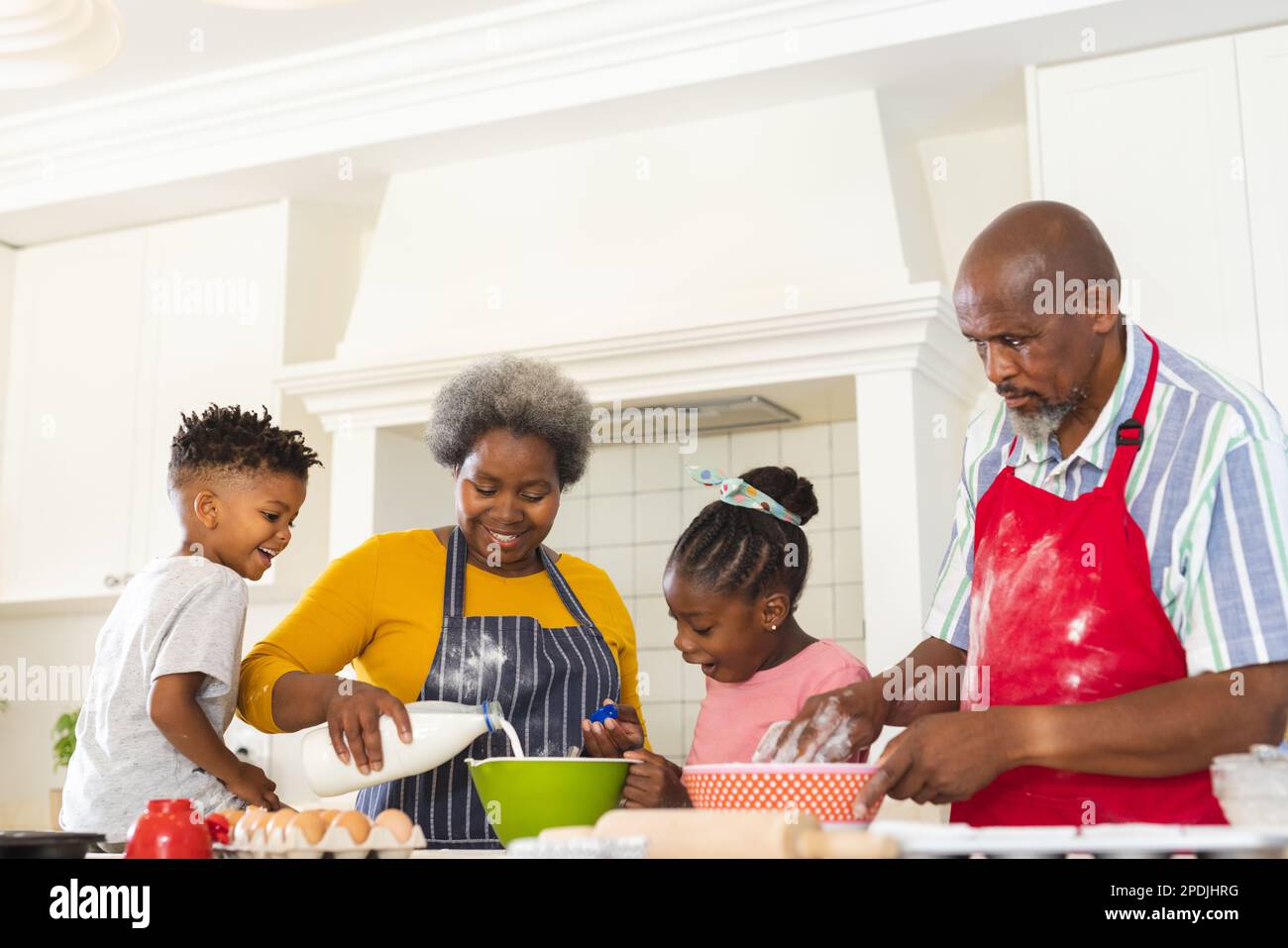Glückliche afroamerikanische Großeltern und Enkel, die zusammen in der Küche backen Stockfoto