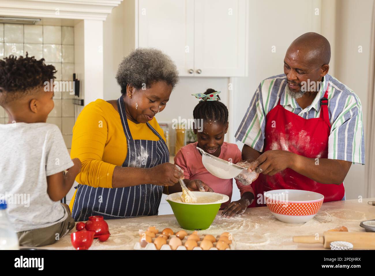 Glückliche afroamerikanische Großeltern und Enkel, die zusammen in der Küche backen Stockfoto