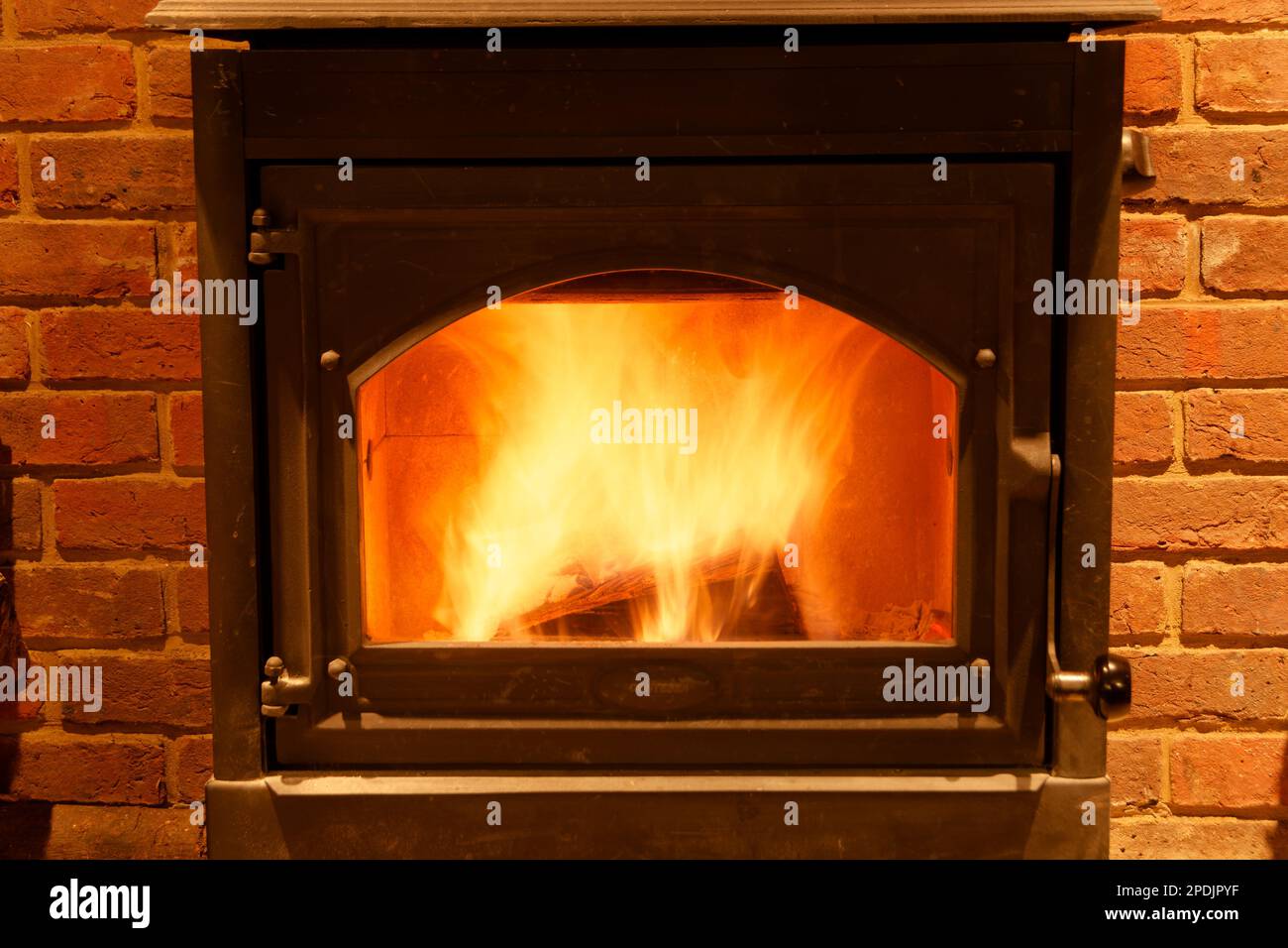 Ein wunderbares Kaminfeuer in einem Holzofen. Ein wunderbares, wärmendes Holzfeuer, sicher umschlossen und optisch ansprechend. Ich liebe den Anblick von brennenden Stämmen. Stockfoto