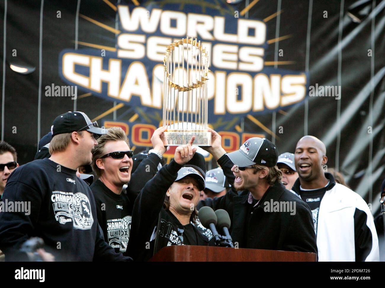 Former Journey frontman Steve Perry, center, leads Chicago White Sox players, from left, A.J. Pierzynski, Geoff Blum, Perry, Joe Crede and Jermaine Dye, in the song "Don't Stop Believin'" during the city's celebration of the White Sox World Series championship in downtown Chicago in Friday, Oct. 28, 2005. The song was the team's theme song during the playoffs. (AP Photo/Jeff Roberson) Stockfoto