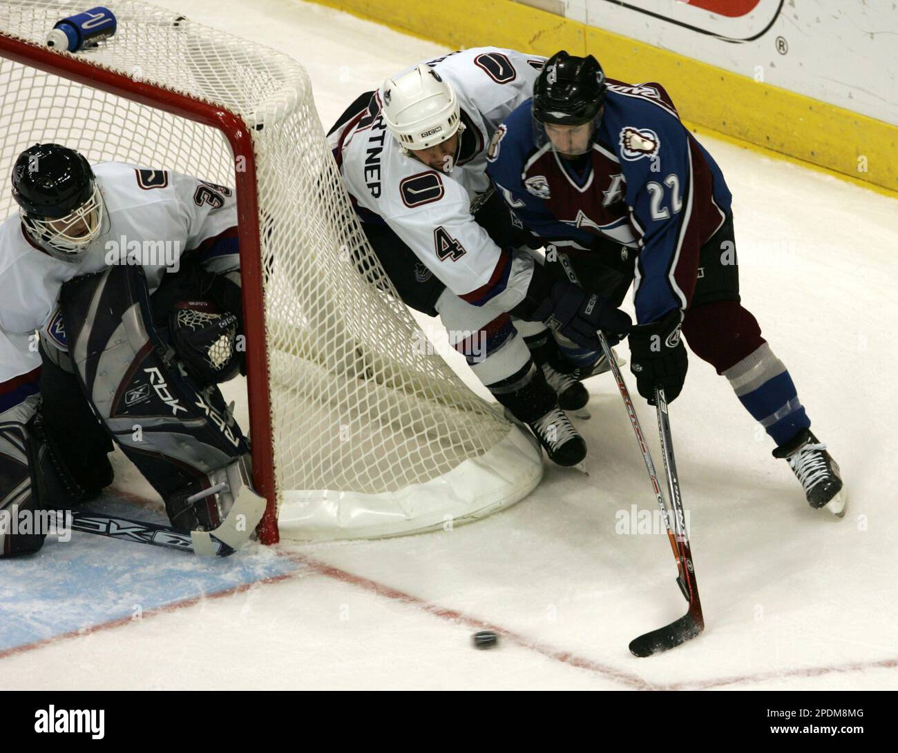 Colorado Avalanche left winger Steve Konowalchuk, right, puts a shot on Vancouver Canucks goalie Dan Cloutier, left, as defenseman Nolan Baumgartner, center, covers in the first period in Denver on Thursday, Oct. 27, 2005. (AP Photo/David Zalubowski) Stockfoto