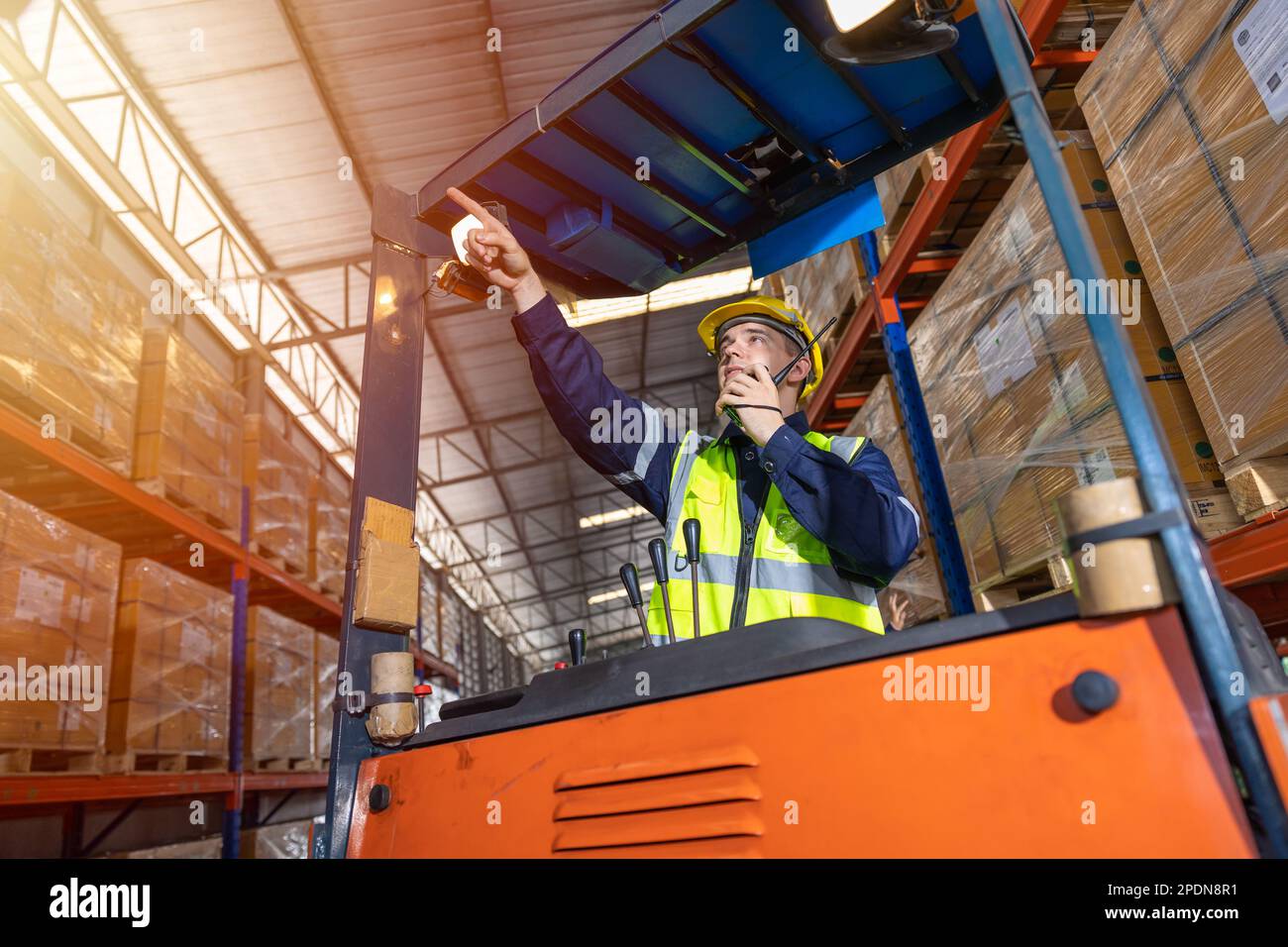 Russischer europäischer männlicher Mitarbeiter, der für die Kontrolle der Beladung zuständig ist, betreibt einen Volkslift in der Lagerbestandsfabrik Stockfoto