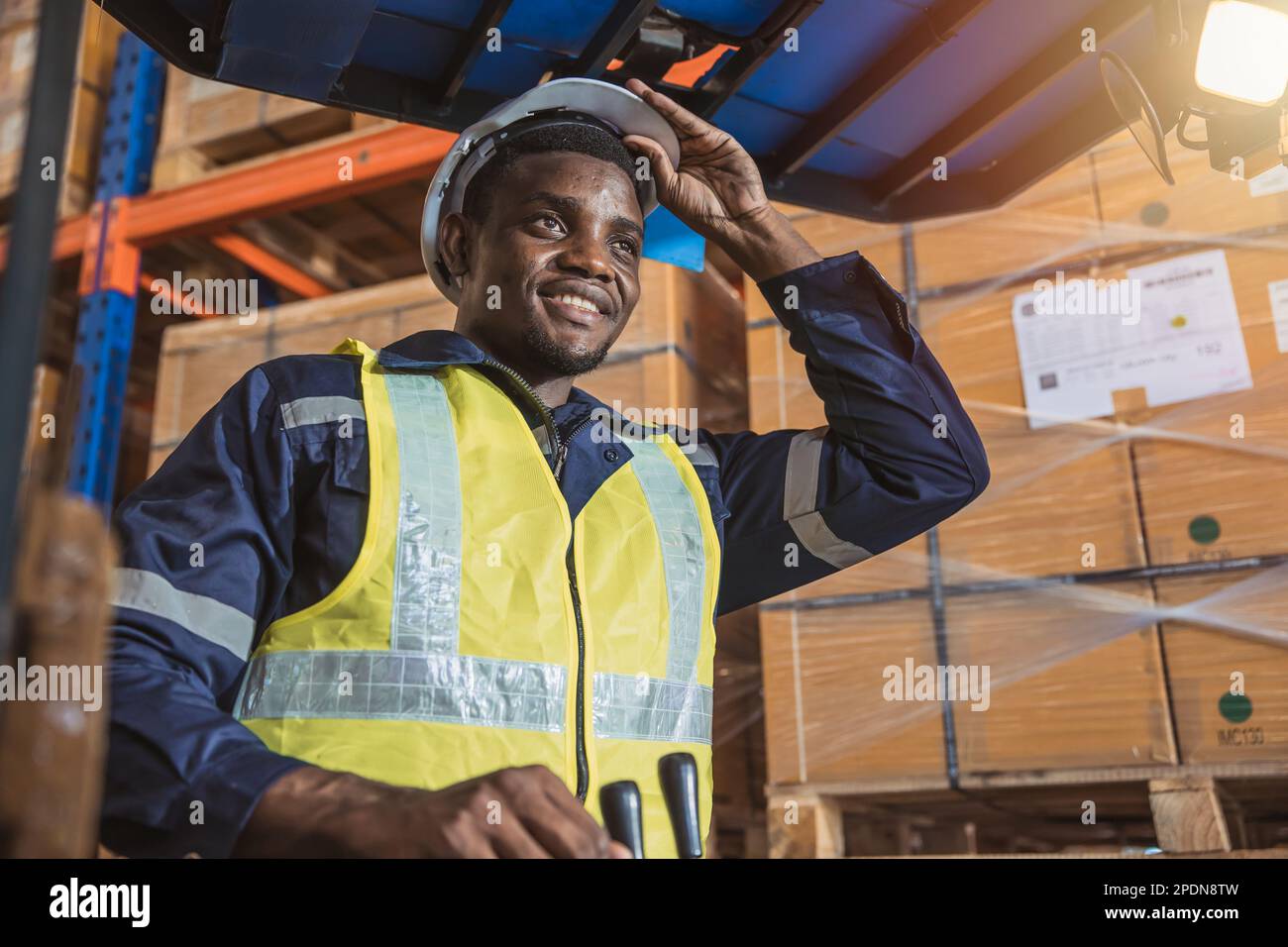 Ein afrikanischer schwarzer Angestellter genießt eine glückliche Arbeit in einem Lastwagen im Lagerbestand. Stockfoto