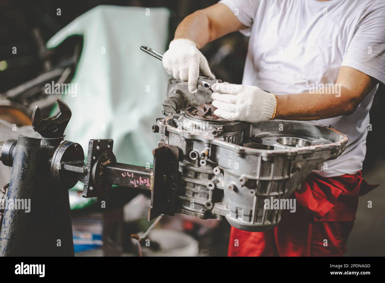 Werkstattmechaniker repariert mechanische Teile des alten, kaputten Fahrzeugmotors Stockfoto