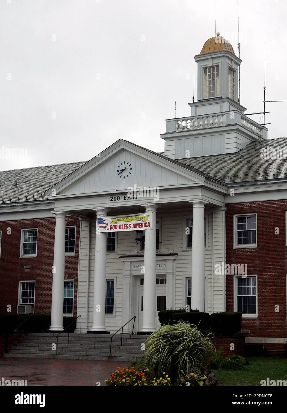 A sign reading "God Bless America" hangs outside of Babylon Town Hall